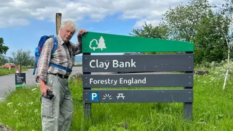 Keith Ogley stands with a sign for Clay Bank in North Yorkshire