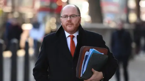 Getty Images George Freeman is a middle aged man, with a balding head and red facial hair.