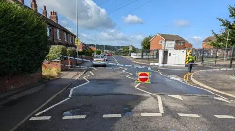 BBC/David Spereall Police at the scene in Heights Drive