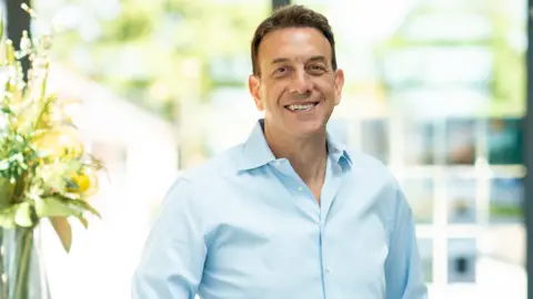 Dorchester Living A man wearing a blue shirt smiling