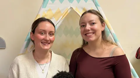 Rebeka Fisher (left) and Laura Thoeling are pictured in front of an indoors tipi 