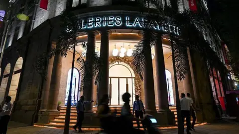 Pedestrians walk past the Galeries Lafayette store ahead of its launch in Mumbai on October 15, 2025. 