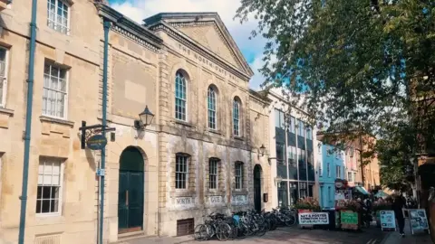 A general view picture of the chapel building and the office building next to it further down the road.