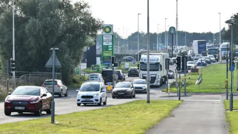 Queues of traffic at the M5 Ashchurch Junction near Tewkesbury with a petrol station in the background.