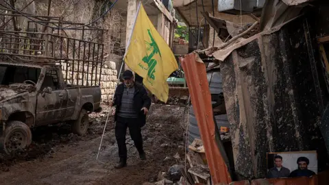 Getty Images A man holds a Hezbollah flag. 