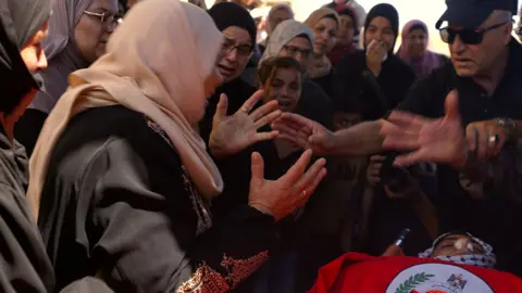 Fred Scott, BBC Mother of 18-year-old Hamdan Abu-Elaya cries at his funeral, after he was shot and killed by Israel troops