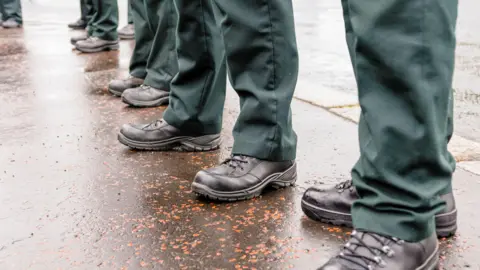 Getty Images Police officers' boots as they stand in line. It's been raining.