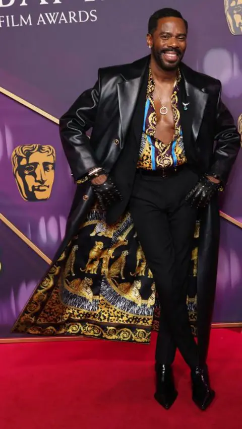 Getty Images Colman Domingo wore a long jacket lined in gold and silver, with a colourful, open shirt to match