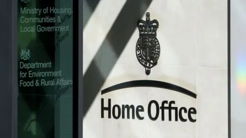 A sign saying 'Home Office' is seen to an entrance to the Home Office building in London