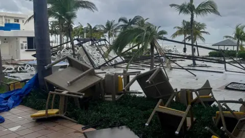 Stephen Ramsden Upended outdoor furniture outside a hotel in the aftermath of Hurricane Melissa.