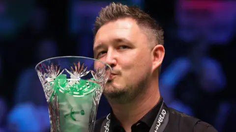 Kyren Wilson kisses the Players Championship trophy after beating Judd Trump