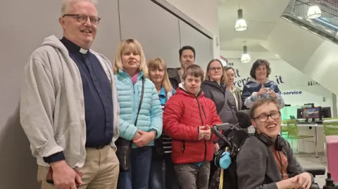 LDRS Parents and their disabled children turned out to lobby Telford & Wrekin Council. A group of men, women and young people are gathered together, with a counter visible behind them.