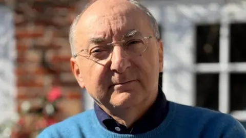 Peter Kosminsky wearing glasses and a blue jumper