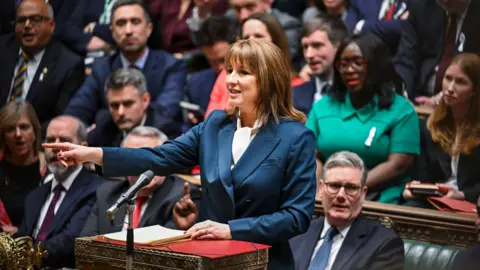 House of Commons The Chancellor, Rachel Reeves, standing at the despatch box in the House of Commons with the prime minister sat behind her along with other MPs.