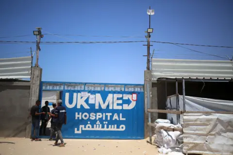 UK-Med A blue metal gate bearing the words 'UK Med Hospital'