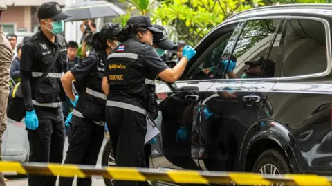 Reuters Forensic police officers inspect the site of a shooting after former lawmaker Chalong Riewrang allegedly shot Thongchai Yenprasert, president of the Nonthaburi Provincial Administrative Organisation, in Nonthaburi province, on the outskirts of Bangkok, Thailand, August 10, 2026