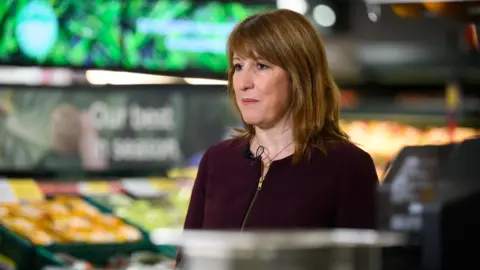 Leon Neal/PA Wire Chancellor of the Exchequer Rachel Reeves speaking to the media about inflation - she is stood inside a supermarket.