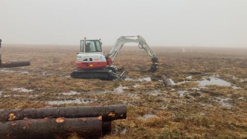 Digger working in peat bog.