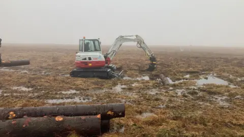 BBC Digger working in peat bog.