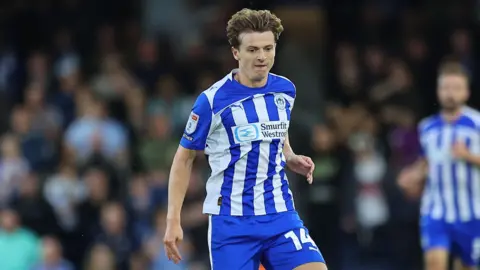 Ryan Treveitt running with the ball at his feet during a match for Wigan