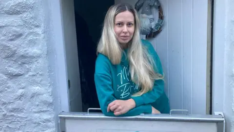 Olga Cheborava in front of her home