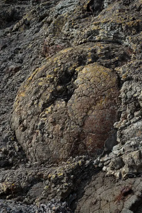 Jon Pountney Industrial slag mixed with rock on a beach