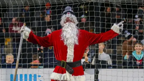 Chorley FC/David Airey Santa in goal wearing a Chorley FC hat