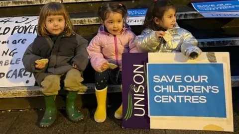 Save Children's Centers in Hackney Children hold campaign banners and say: "Save our children's centers"