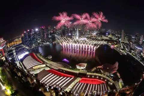 Suhaimi Abdullah / Getty Images Fogos de artifício iluminam o céu para inaugurar o ano novo em 1º de janeiro de 2025 em Cingapura, Cingapura.