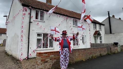 Walter Gunston outside his house with flags on