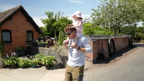 baby sitting on fathers shoulders