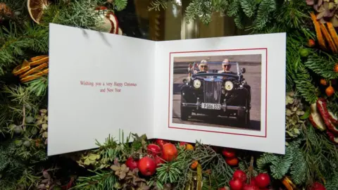 Getty Images Prince Charles's Christmas card from 2019, featuring the prince driving a classic sports car, with Camilla sitting in the front passenger seat. The message says: Wishing you a very Happy Christmas and New Year.