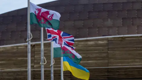 Getty Images A set of flags flying outside the Senedd - two Welsh flags, a union jack flag and a Ukraine flag.