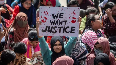 Protesters hold placards during the demonstration outside the High Court building demanding justice for the victims arrested and killed in the recent countrywide violence