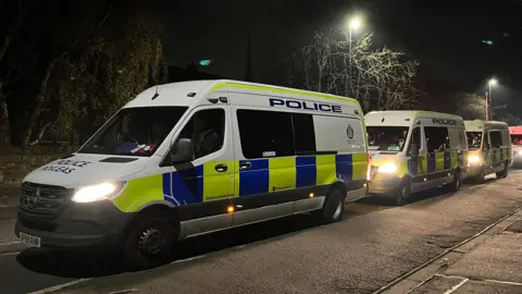 A line of police vans in Niddrie, Edinburgh.