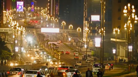 De डिस अबाबा मधील ड्युअल कॅरिझवे नाईटमध्ये आमेनिसा आयएफए/बीबीसी रहदारी. नवीन वर्षाच्या संदेशांमध्ये पोस्टर्स आणि जाहिराती पाहिल्या जातात. इथिओपिया - बुधवार 10 सप्टेंबर