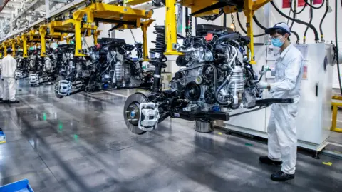 Employees work on assembly line at Dongfeng Honda Automobile factory in China.