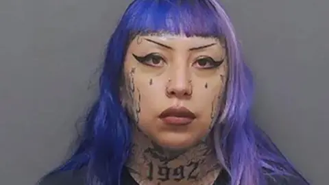 Ashley Pardo has purple hair and tattoos on her face and neck