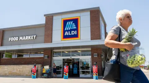 Getty Images  A customer walks out of an Aldi supermarket on August 17, 2023 in Pflugerville, Texas.
