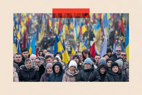 Getty Images People stand near graves during memorial services at the Lychakiv military cemetery in Lviv, Ukraine (2024)