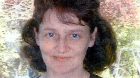 Family photograph Linda Razzell in an old photograph which is slightly faded. She has long dark brown hair and is smiling at the camera