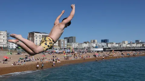 Reuters A young man jumps off a seawall into the sea at Brighton seafront on Monday