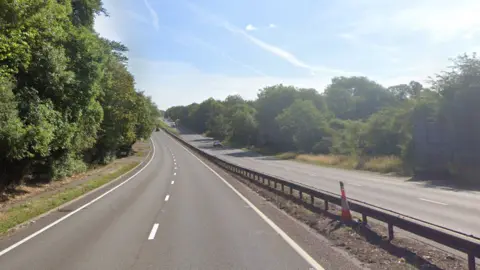 A general view of the A12 northbound carriageway in Suffolk. The road only has several cars on it pictured in the distance. Trees line the carriageway.