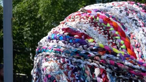 Jacob Tomlinson/BBC A giant ball of yarn consisting of various colours.