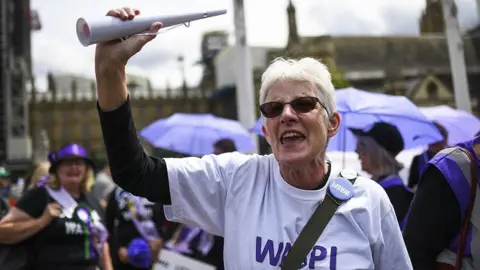 Getty Images Para juru kampanye Waspi di luar Parlemen mengenakan lencana dan kaos tentang kampanye mereka.