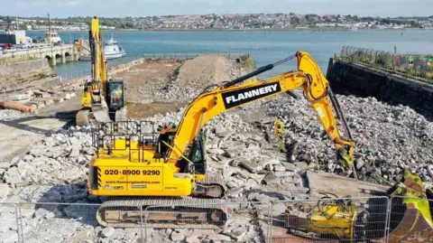 Escavadeiras da Autoridade Portuária de Milford Haven durante trabalhos de construção no porto de Pembroke.