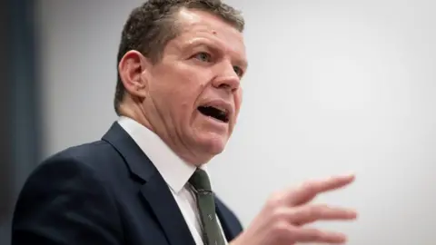 Rhun ap Iorwerth speaking during a news conference at Tŷ Hywel in Cardiff Bay in January. He is gesticulating with his hand.