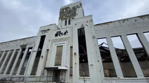 BBC The frontage of the derelict Littlewoods building on Edge Lane, Liverpool, looking up towards the clock tower.