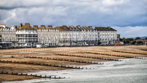 Getty Images Eastbourne beach, showing groynes, pebbles and houses on the seafront.