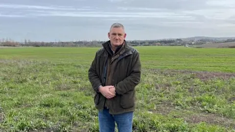 Robert Shove stands in his arable farmland near Chalk